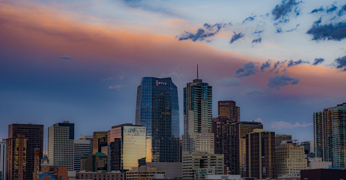 Denver's downtown skyline with the Rocky Mountains behind it