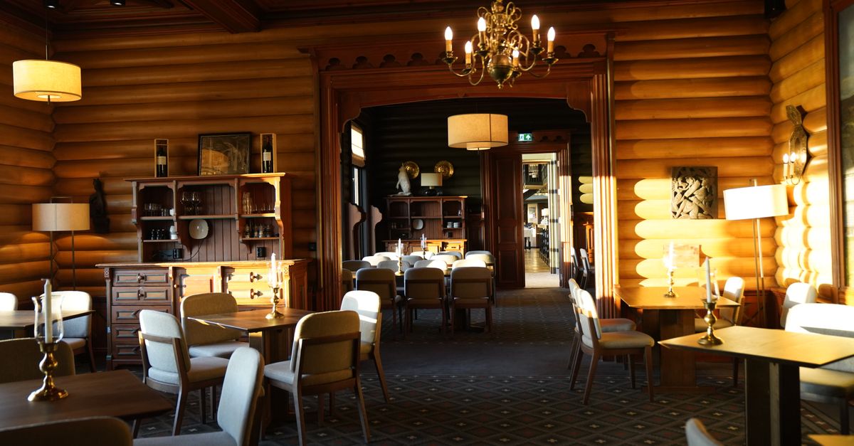 A warm rustic restaurant dining room with timber walls